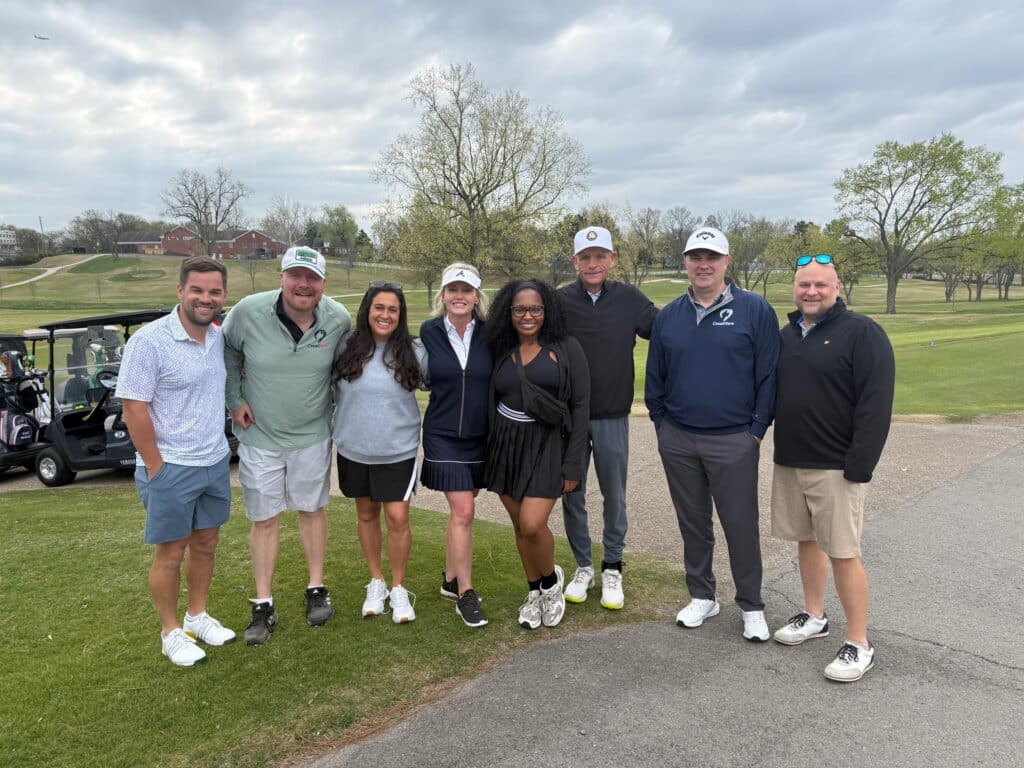 Centinel employees pose for a photo on a golf course at the CreatiVets golf tournament.